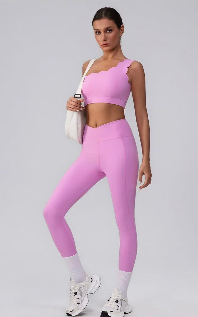 Woman wearing a pink athletic outfit on a gray background