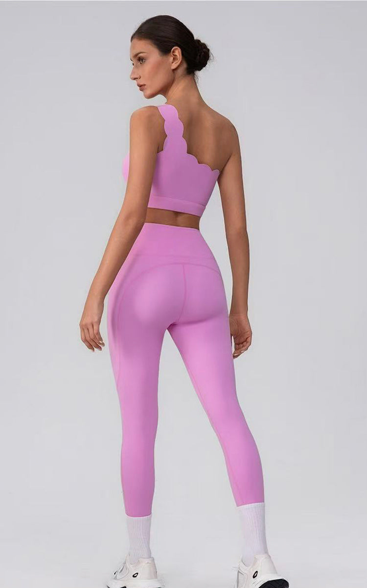 Model wearing a pink athletic outfit on a light gray background