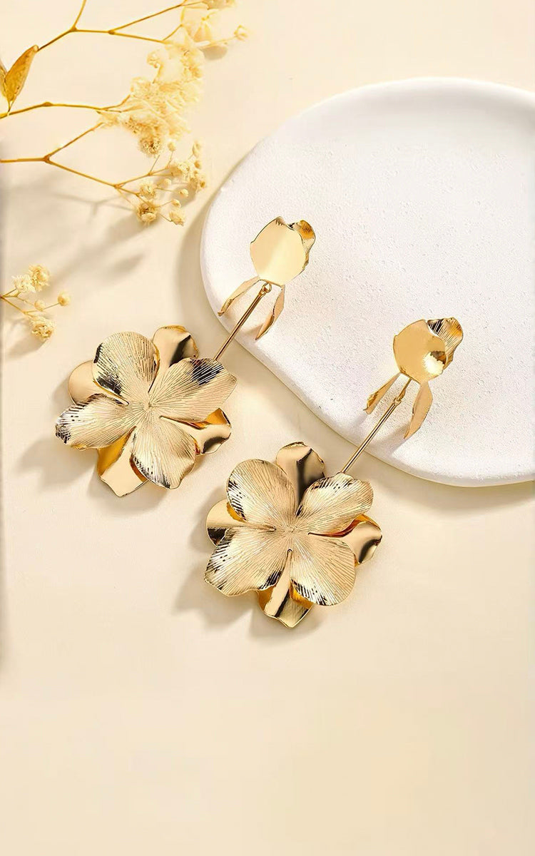 Model wears Grand Bloom Earrings that featuring a tiered petal design, they capture a flower in full bloom for a chic, organic touch. 