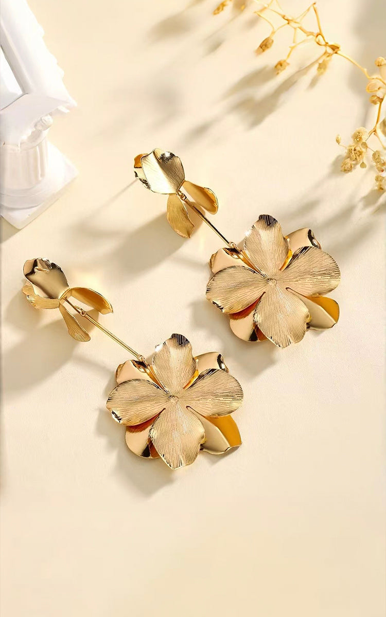 Model wears Grand Bloom Earrings that featuring a tiered petal design, they capture a flower in full bloom for a chic, organic touch. 