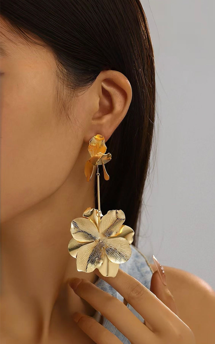Model wears Grand Bloom Earrings that featuring a tiered petal design, they capture a flower in full bloom for a chic, organic touch. 