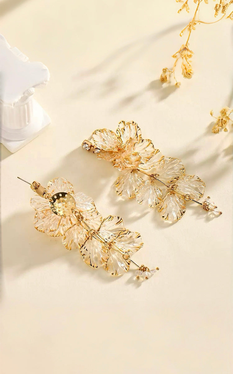 Yellow floral earrings on a beige background