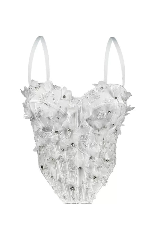 White top with floral and bead details on a white background