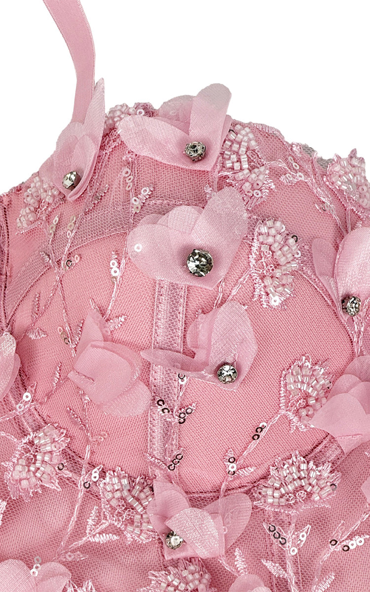 Pink top with floral embellishments and beads on a white background